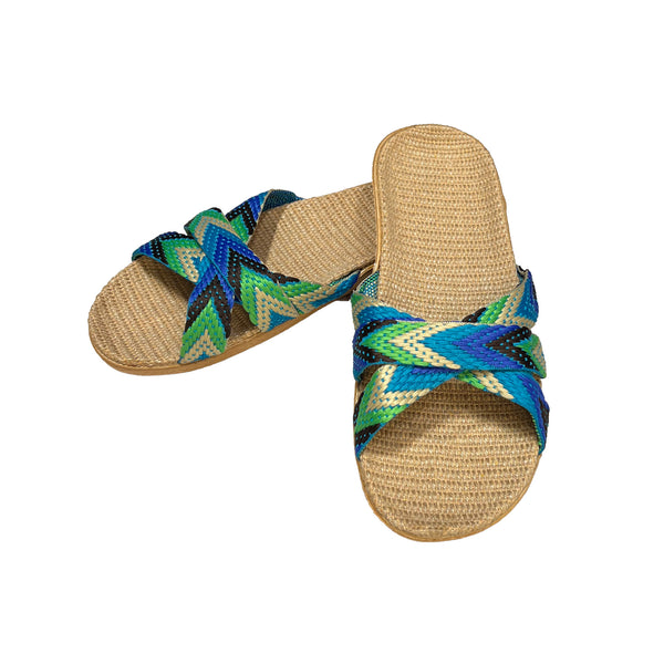 Pair of woven sandals with blue and green straps on a white background