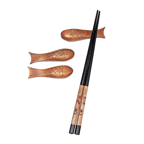 Three wooden fish chopstick rests with one pair of chopsticks